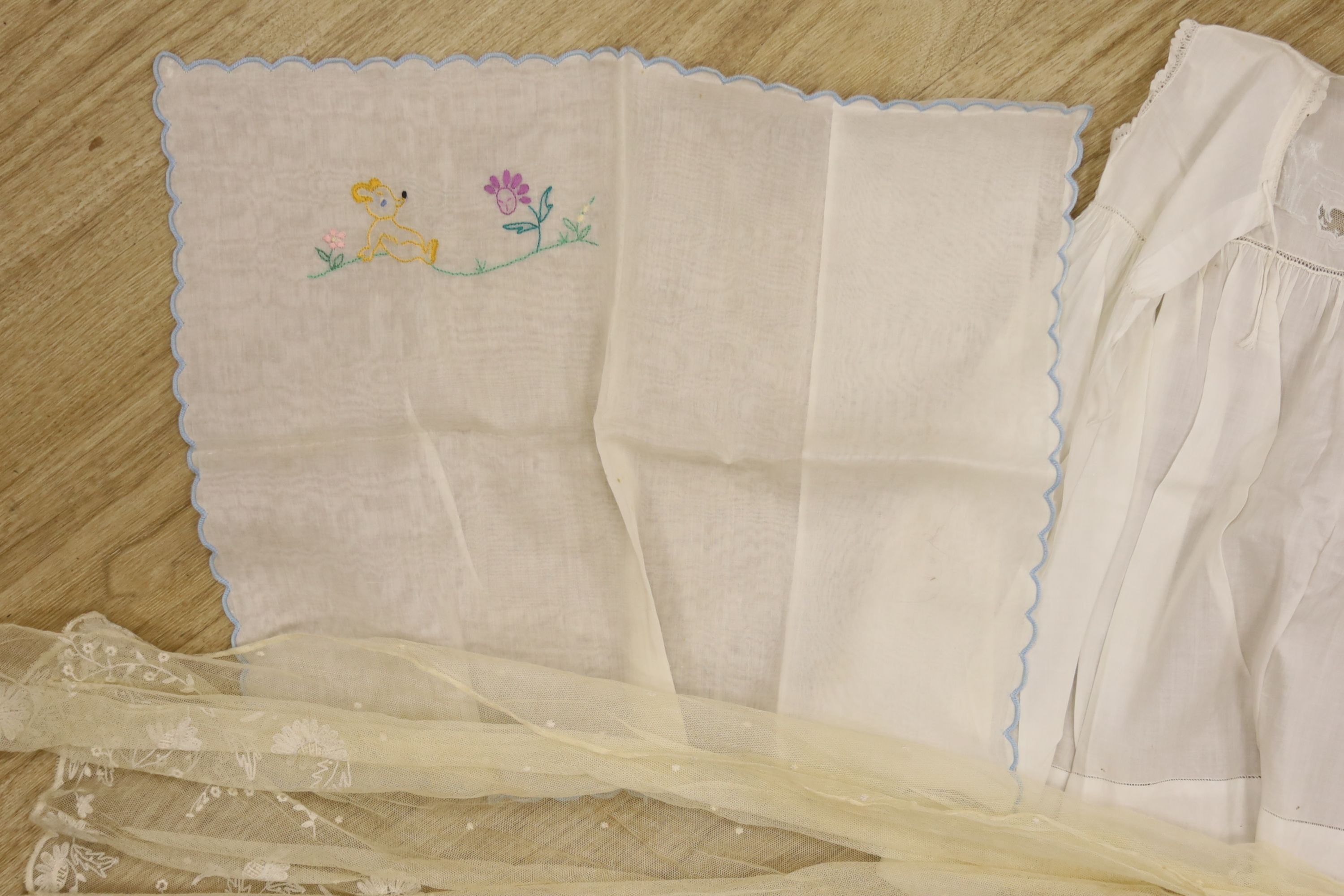 A 1920's needle run embroidered christening gown, on cream net, two whitework baby gowns and a pillow case